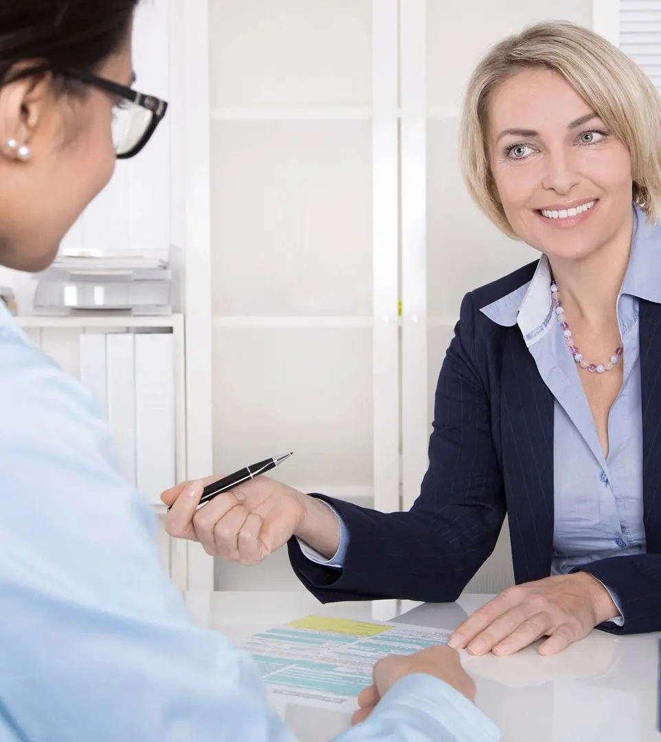 A woman is sitting at the table with another person.