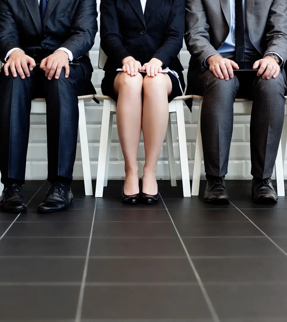 Three people sitting in a row of chairs.