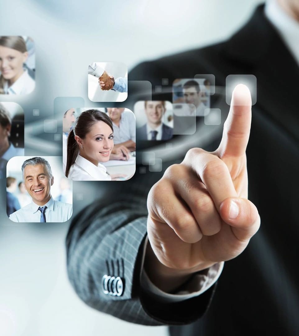 A man in business attire pointing to several pictures of people.