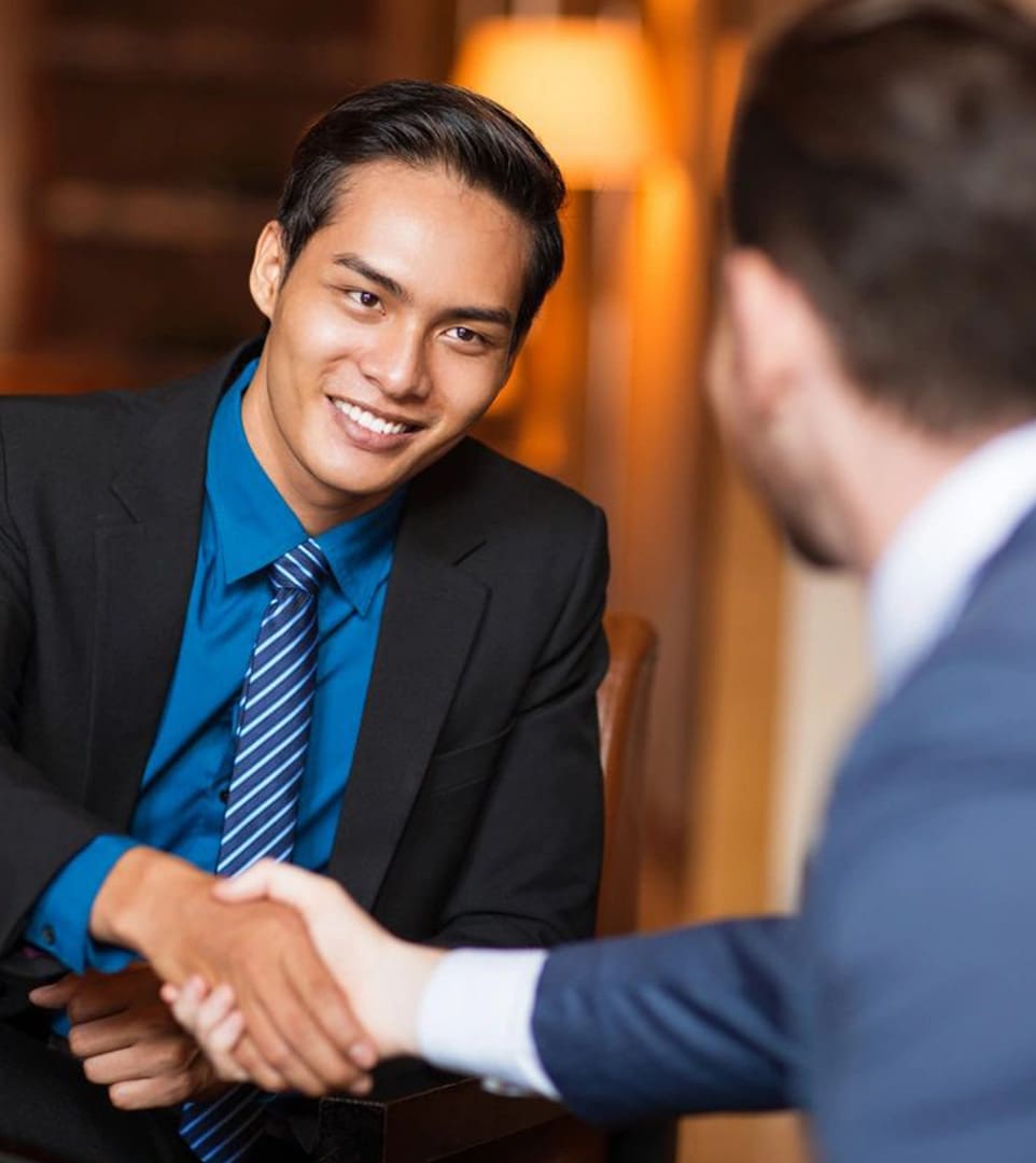 Two men shaking hands in a room.