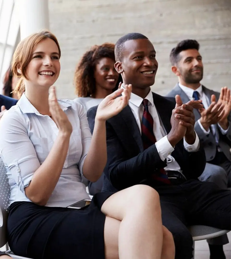 A group of people sitting in front of each other clapping.